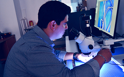 Engineer reviewing a medical device prototype under magnification